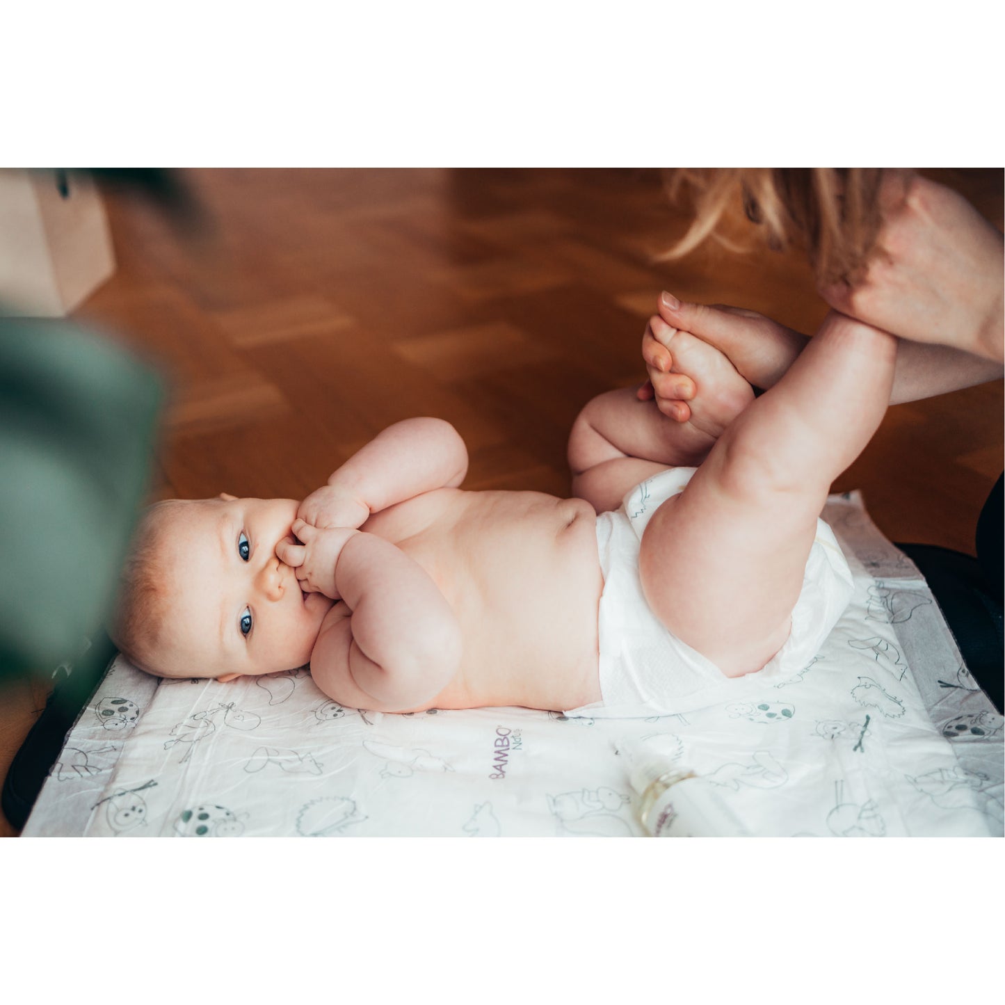 Baby wearing Bambo Nature diaper lying on breathable changing mat – skin-safe baby care essentials